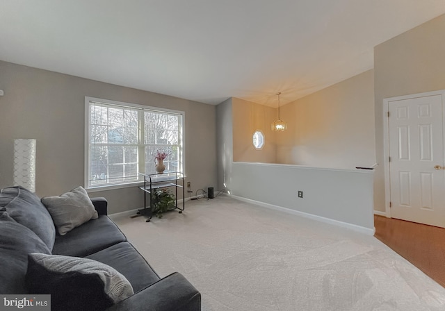 carpeted living room featuring a notable chandelier