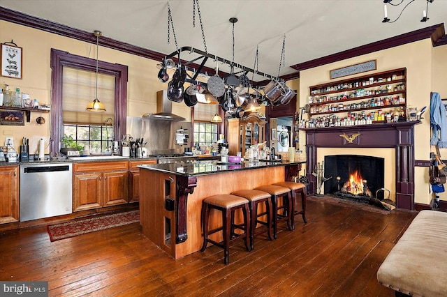 kitchen featuring crown molding, stainless steel dishwasher, a kitchen island, dark hardwood / wood-style flooring, and a breakfast bar area