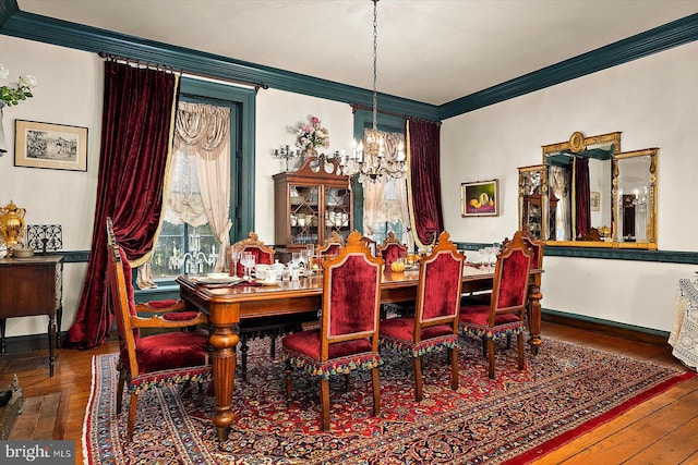 dining area with crown molding, hardwood / wood-style floors, and a chandelier