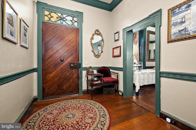 foyer featuring crown molding and dark hardwood / wood-style flooring