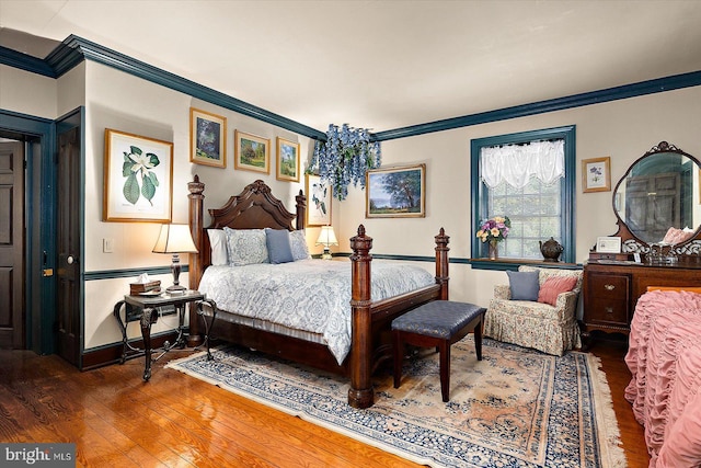 bedroom with ornamental molding and dark wood-type flooring