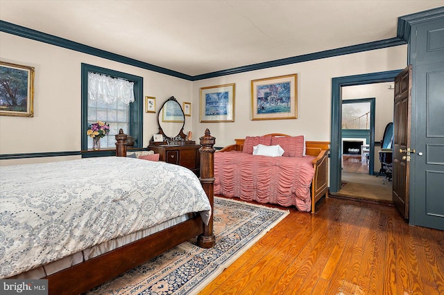 bedroom with dark hardwood / wood-style flooring and ornamental molding