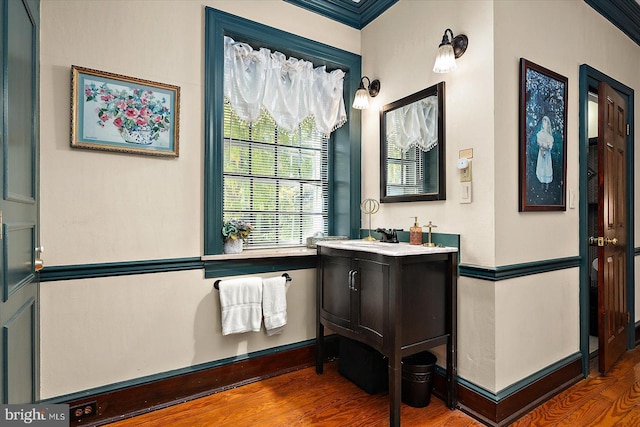 bathroom with hardwood / wood-style floors, vanity, and crown molding