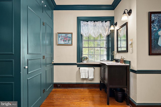 bathroom with hardwood / wood-style floors, vanity, and ornamental molding