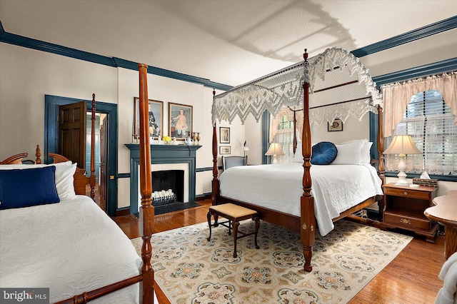 bedroom featuring wood-type flooring and ornamental molding