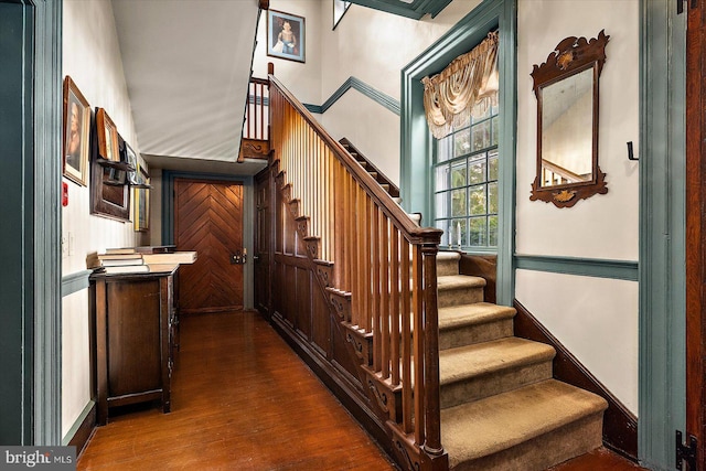 stairway featuring a high ceiling and hardwood / wood-style flooring