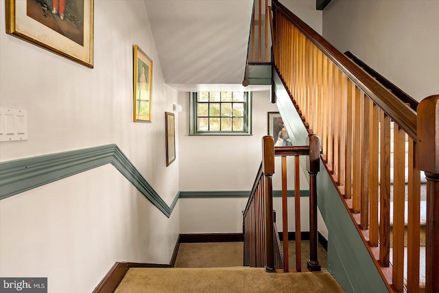 staircase with carpet flooring and lofted ceiling