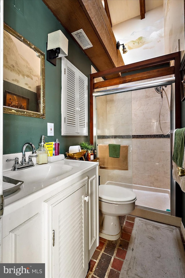 bathroom featuring a tile shower, vanity, and toilet