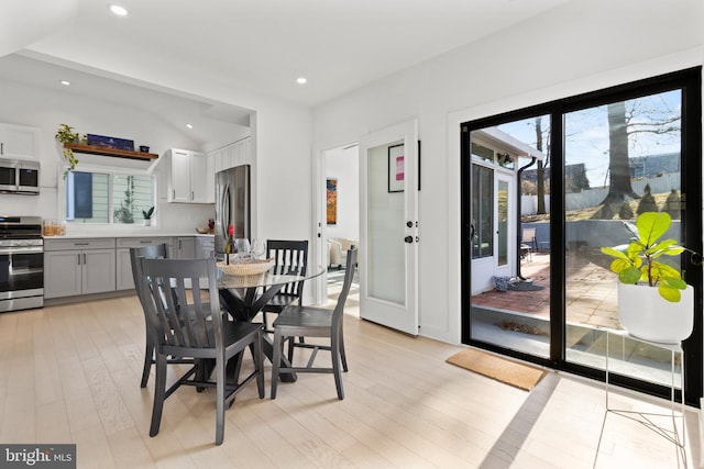 dining room featuring vaulted ceiling and light wood-type flooring