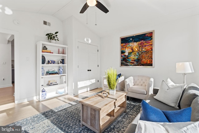 living room with ceiling fan, vaulted ceiling, and wood-type flooring