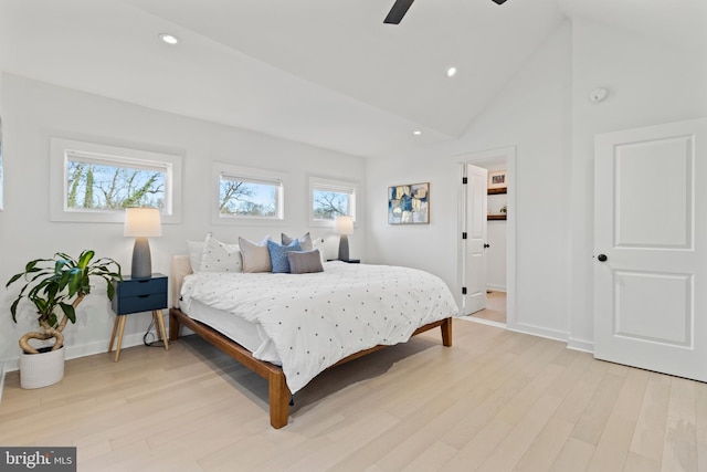 bedroom featuring multiple windows, ceiling fan, high vaulted ceiling, and light hardwood / wood-style flooring