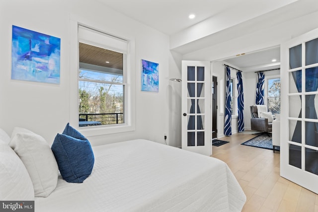 bedroom with french doors and light wood-type flooring