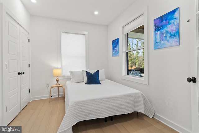 bedroom with light hardwood / wood-style floors and a closet