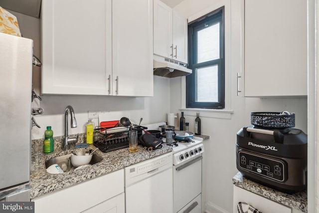 kitchen with light stone countertops, white appliances, white cabinetry, and sink