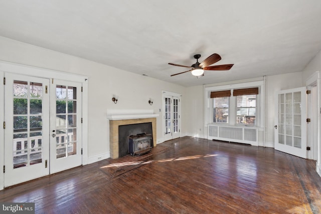 unfurnished living room with plenty of natural light, radiator, french doors, and dark hardwood / wood-style flooring