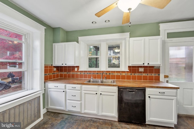 kitchen with backsplash, white cabinets, sink, black dishwasher, and radiator heating unit