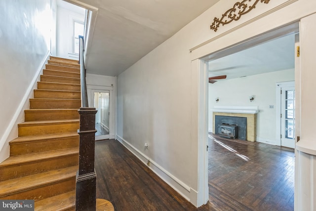 stairway featuring a wood stove and hardwood / wood-style floors