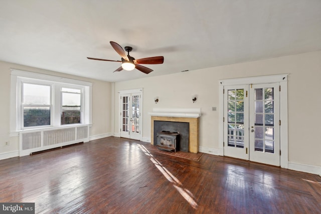 unfurnished living room featuring dark hardwood / wood-style floors, ceiling fan, radiator heating unit, and french doors