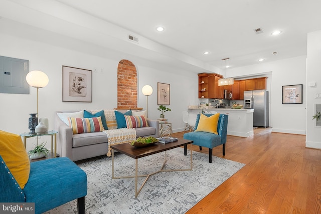 living room featuring electric panel and light hardwood / wood-style flooring