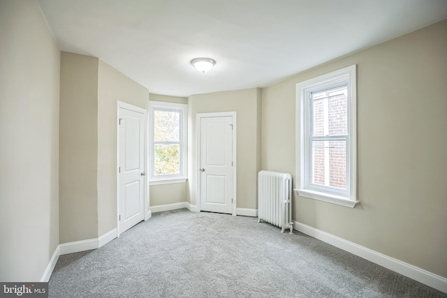 spare room featuring radiator and carpet