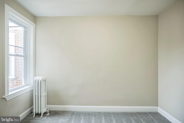 unfurnished room featuring carpet flooring, radiator heating unit, and plenty of natural light