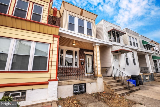 townhome / multi-family property with cooling unit and covered porch