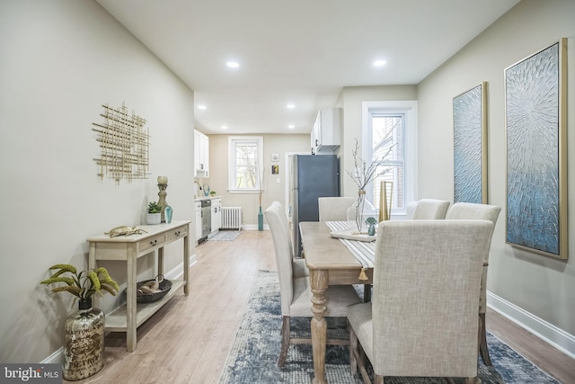 dining room featuring radiator heating unit and light wood-type flooring