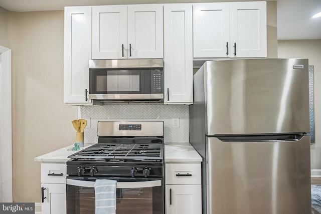 kitchen featuring decorative backsplash, light stone counters, white cabinetry, and stainless steel appliances