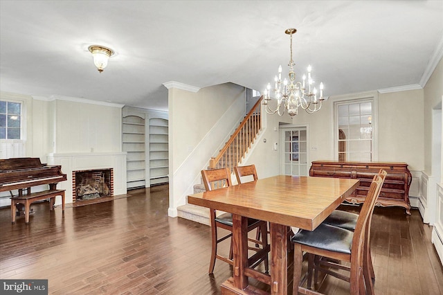 dining area with a fireplace, crown molding, dark hardwood / wood-style flooring, and a chandelier