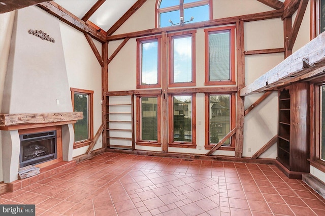 unfurnished living room featuring tile patterned flooring, high vaulted ceiling, and beamed ceiling