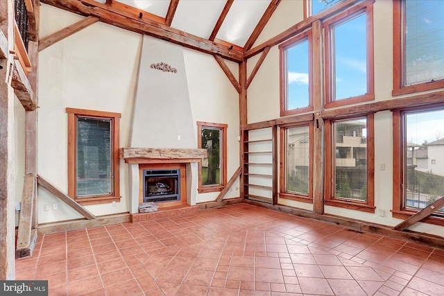 unfurnished living room with tile patterned floors, beam ceiling, and high vaulted ceiling