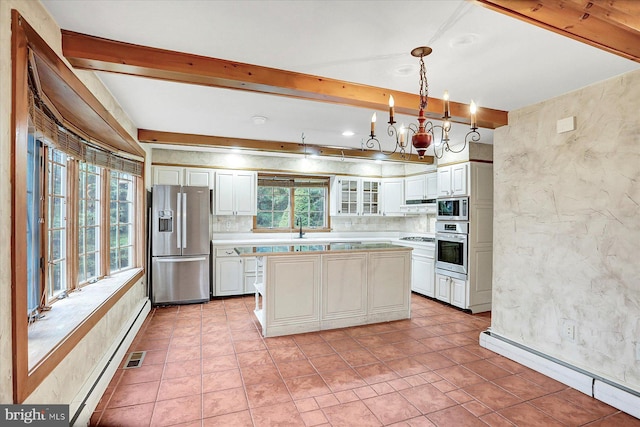 kitchen featuring plenty of natural light, a center island, decorative light fixtures, and appliances with stainless steel finishes