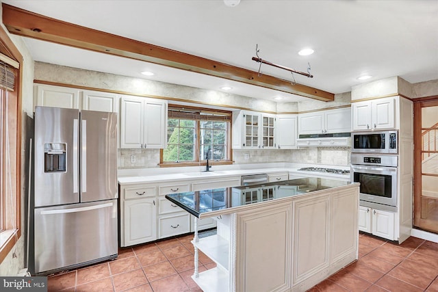 kitchen featuring white cabinets, a kitchen island, light tile patterned floors, and stainless steel appliances