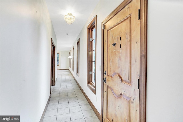 hallway featuring a chandelier and light tile patterned floors