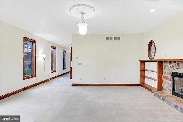 unfurnished living room featuring a fireplace and light carpet