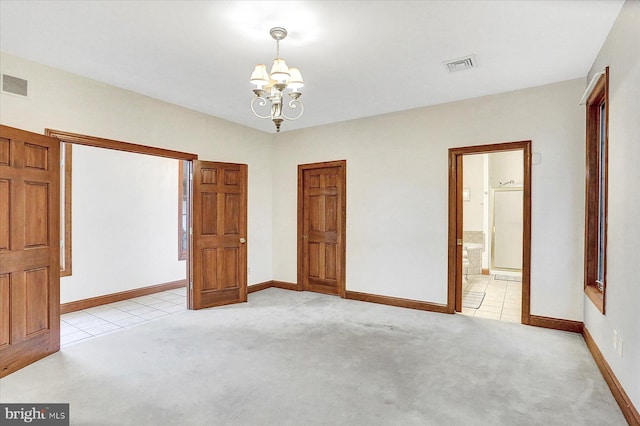 unfurnished bedroom with light carpet, connected bathroom, and a notable chandelier