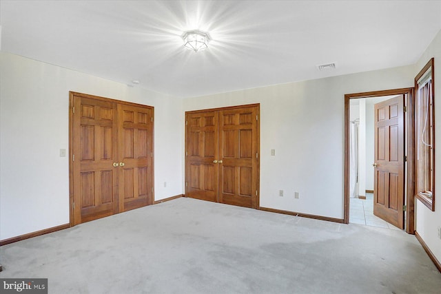 unfurnished bedroom with light colored carpet and a closet