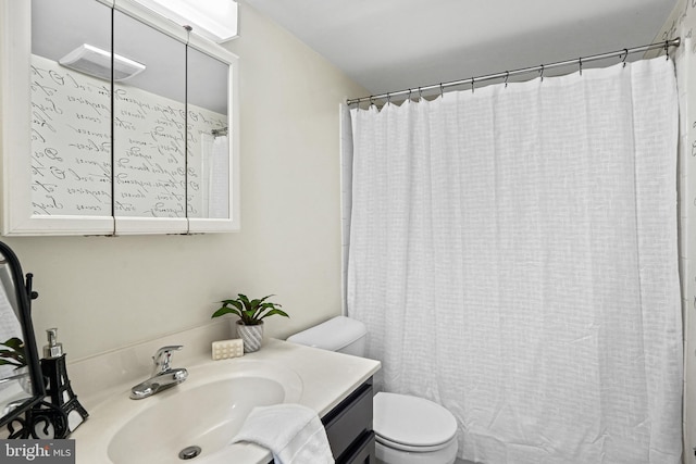 bathroom with vanity, curtained shower, and toilet