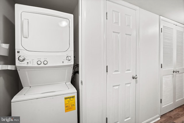 washroom with wood-type flooring and stacked washer and dryer