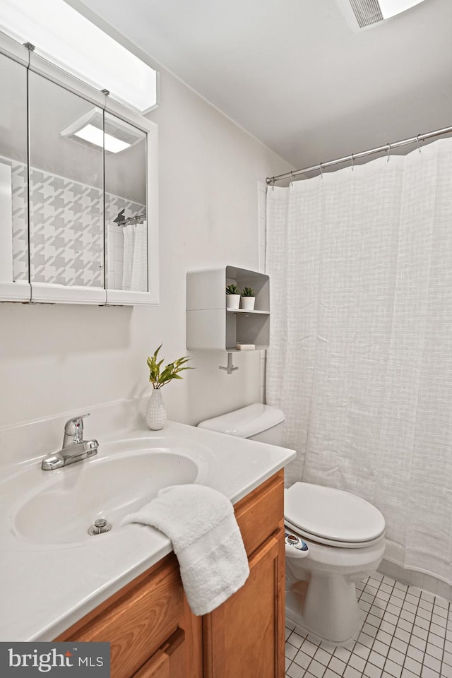 bathroom featuring tile patterned flooring, vanity, and toilet