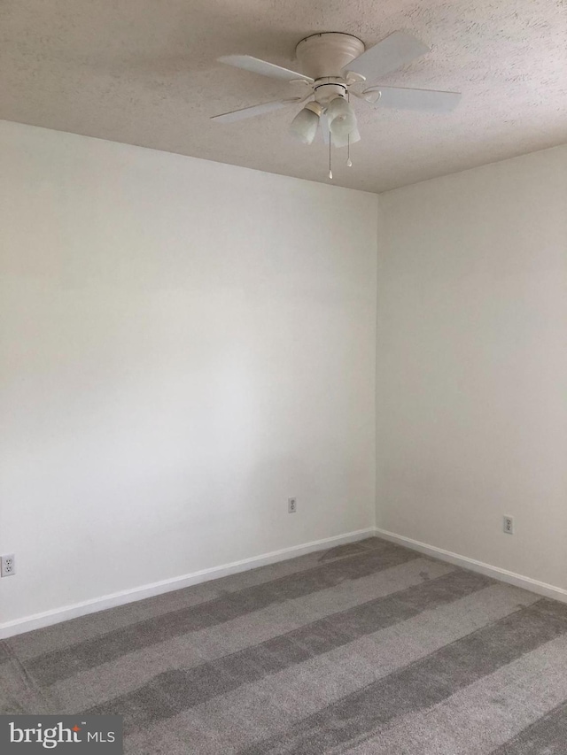 carpeted spare room featuring ceiling fan and a textured ceiling