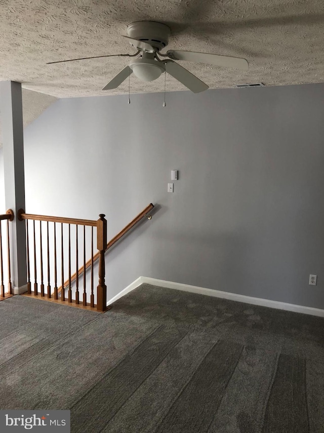 staircase with ceiling fan, carpet, and a textured ceiling