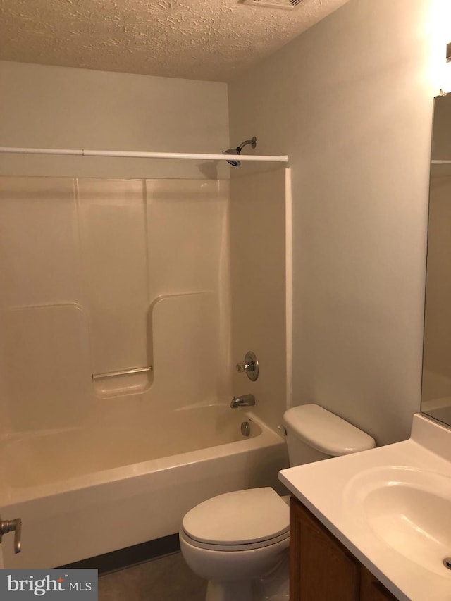 full bathroom featuring vanity, toilet, a textured ceiling, and bathing tub / shower combination