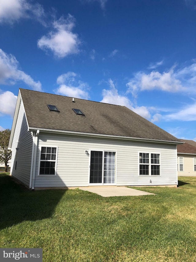 rear view of house with a lawn and a patio