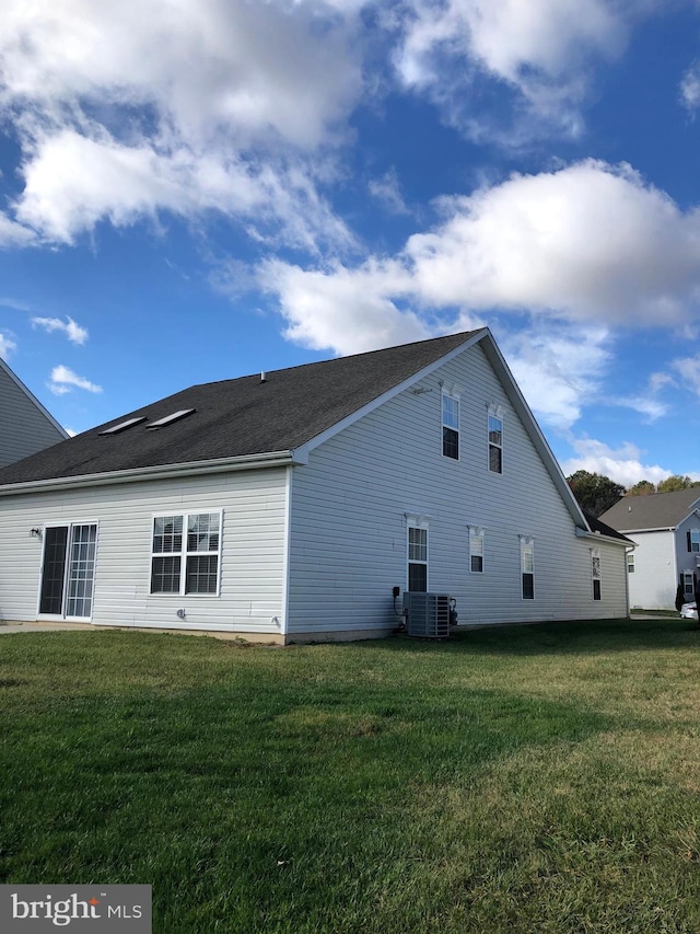 view of side of home featuring a lawn and central air condition unit