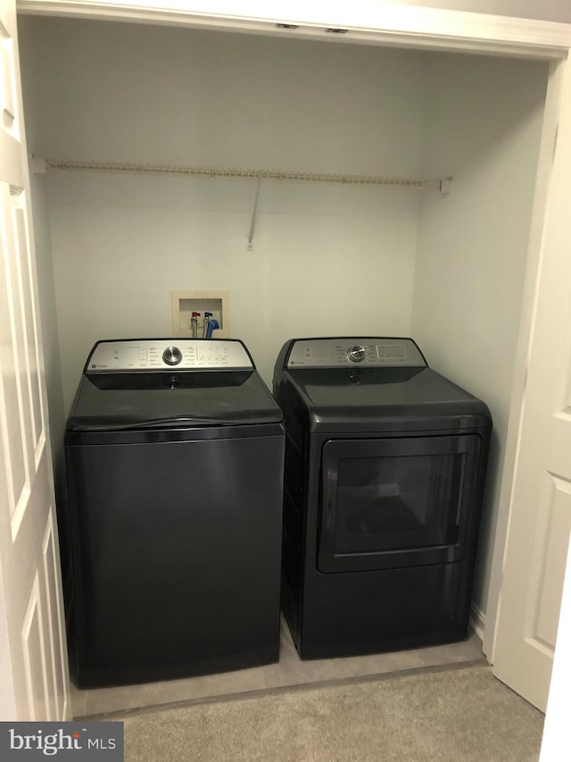 laundry room with separate washer and dryer and carpet floors