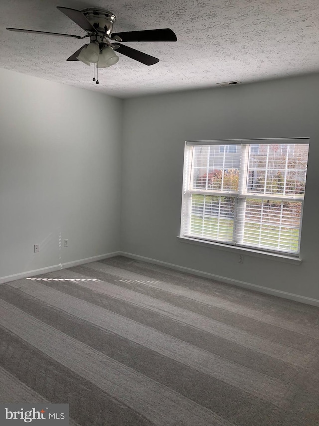 empty room featuring carpet flooring, ceiling fan, and a textured ceiling