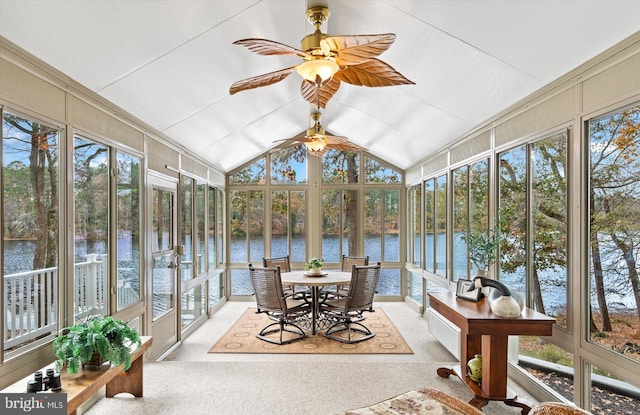 sunroom / solarium featuring lofted ceiling, a water view, and carpet flooring