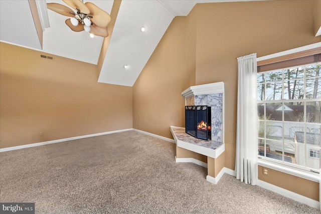 unfurnished living room featuring visible vents, a high end fireplace, baseboards, ceiling fan, and carpet floors