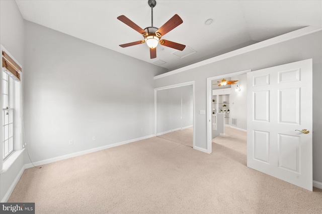 unfurnished bedroom featuring lofted ceiling, baseboards, light colored carpet, and ceiling fan